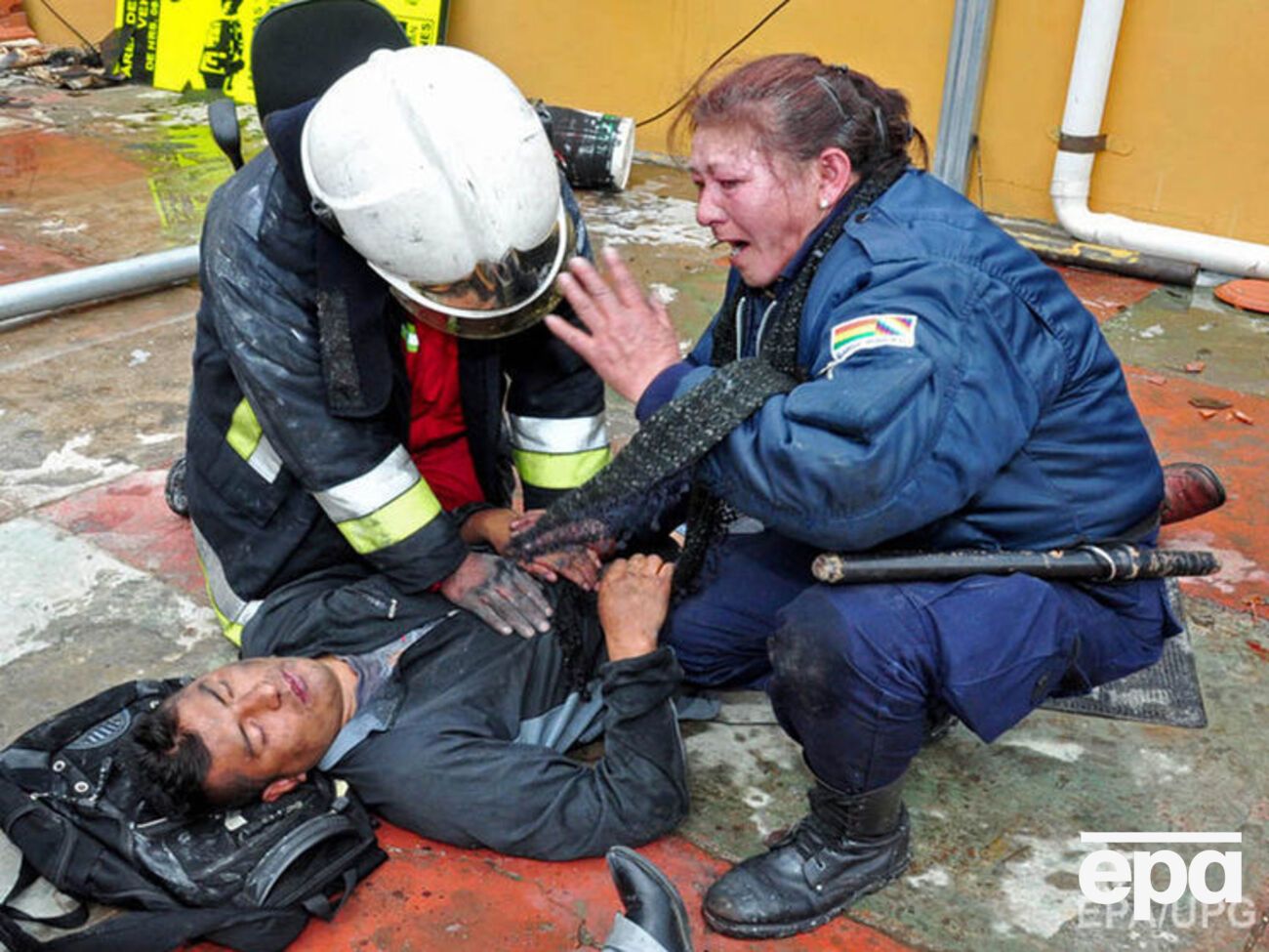 Спасатели оказывают помощь одному из пострадавших при пожаре