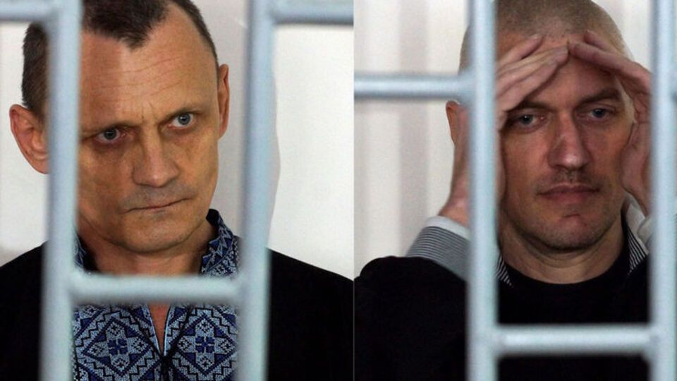 Во время оглашения вердикта Карпюк (на фото слева) спокойно стоял, держась за прутья решетки и сосредоточенно слушая, а Клих (на фото справа) читал газету и не обращал внимания на происходящее