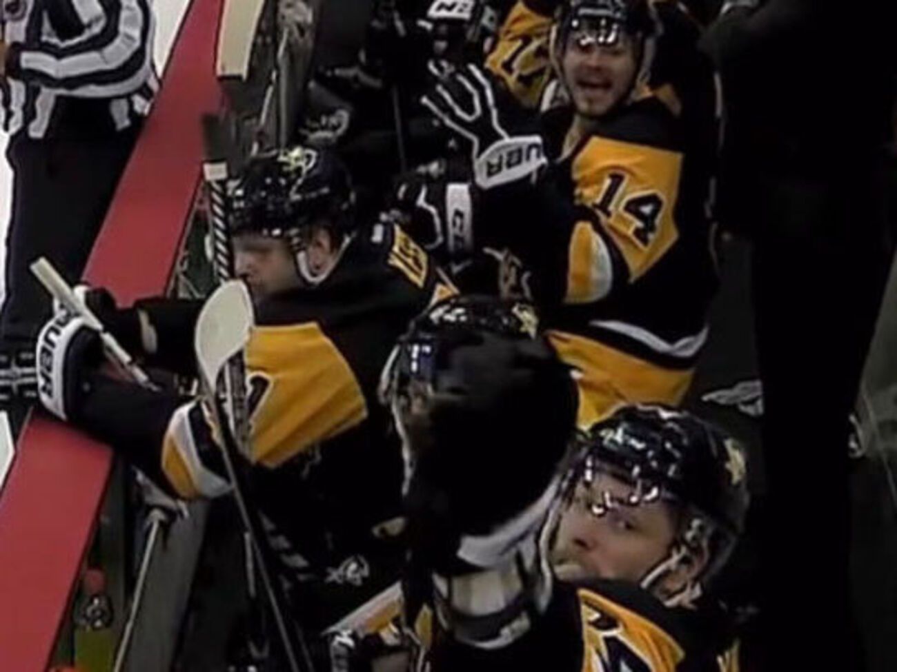 Игрок "Пингвинов" ловит залетевшую на скамейку запасных шайбу