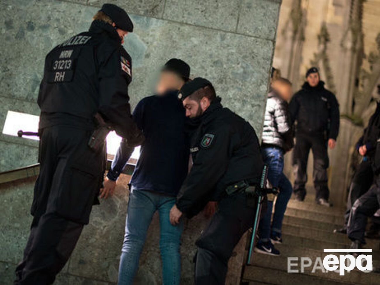 Полиция Кельна досматривает одного из подозреваемых в нападении