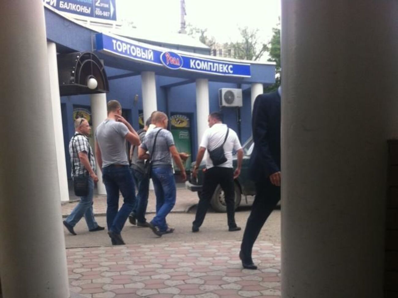 Алексей Салов (крайний слева) направляется с правоохранителями к их автомобилю