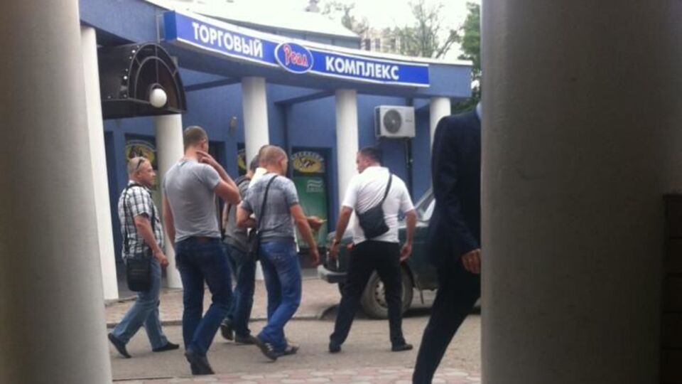 Алексей Салов (крайний слева) направляется с правоохранителями к их автомобилю