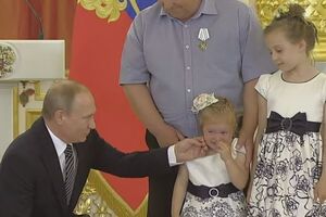 Владимир Путин постарался утешить девочку, погладив ее по щеке и показав на снимающих награждение фотографов