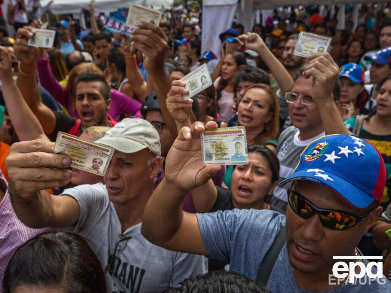 Митингующие в Венесуэле показывают удостоверения личности, утверждая, что подписи за проведение референдума собраны законно