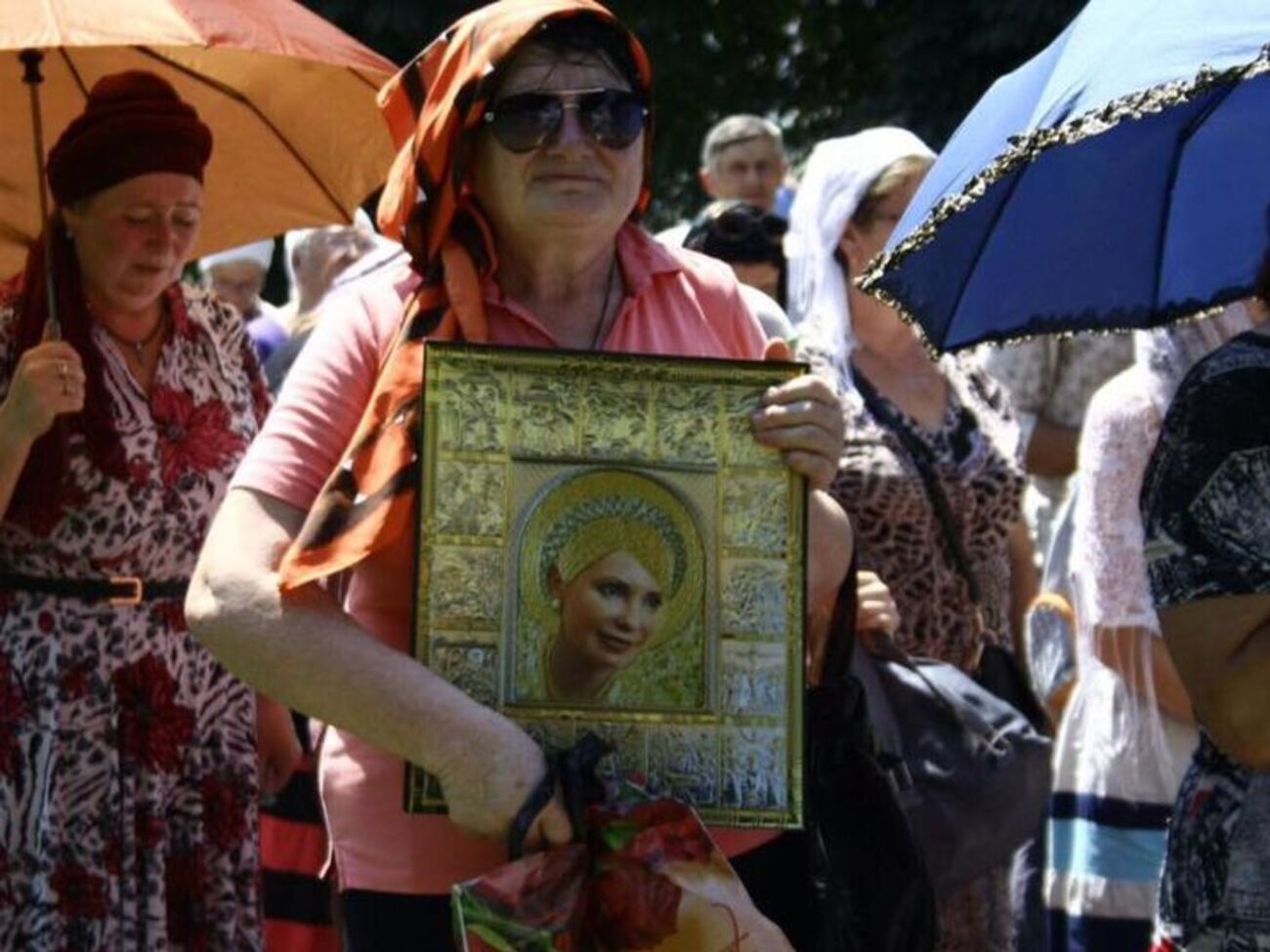 Прихожанка УПЦ МП несет икону с изображением Тимошенко