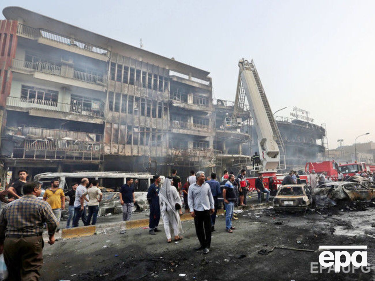 Сгоревшие автомобили и поврежденные взрывом дома в центральном районе Багдада