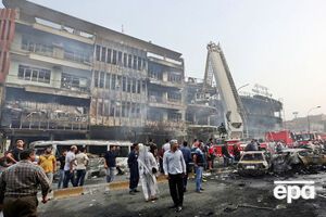 Сгоревшие автомобили и поврежденные взрывом дома в центральном районе Багдада