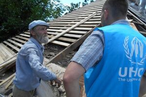 Представители ООН беседуют с жителем Луганской области, дом которого частично разрушен