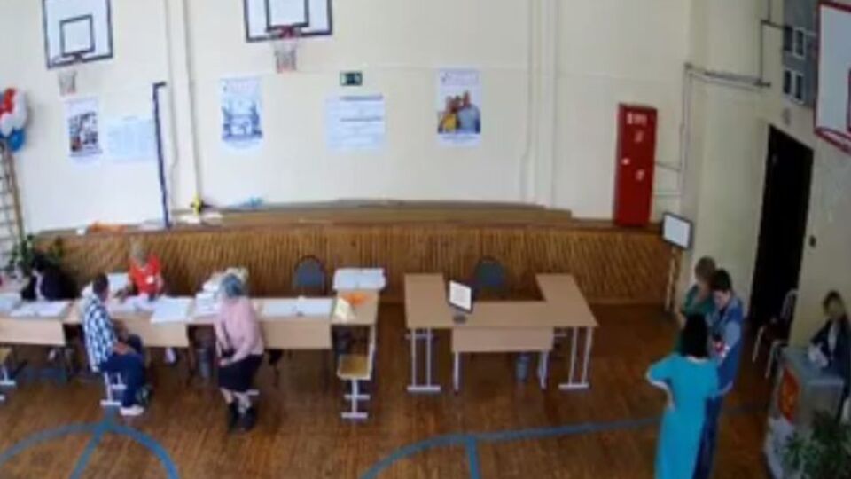 Наблюдатели прикрывают урну для голосования во время вброса бюллетеней