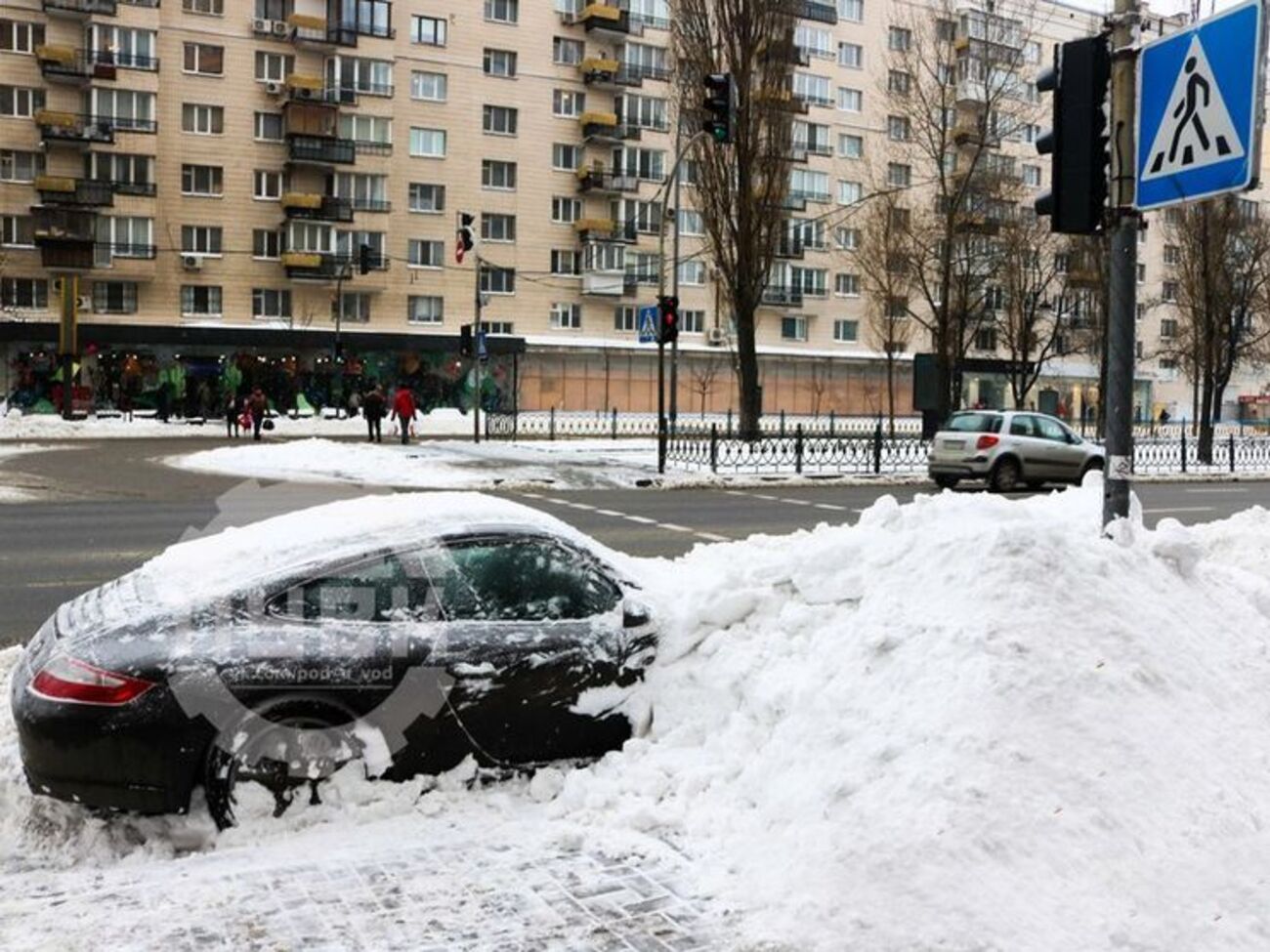 В Киеве коммунальщики засыпали снегом припаркованный Porsche. Фоторепортаж