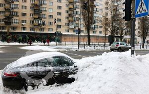 В Киеве коммунальщики засыпали снегом припаркованный Porsche. Фоторепортаж