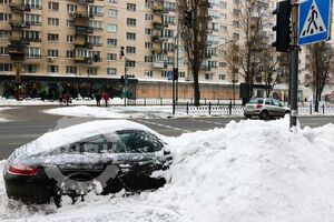 В Киеве коммунальщики засыпали снегом припаркованный Porsche. Фоторепортаж