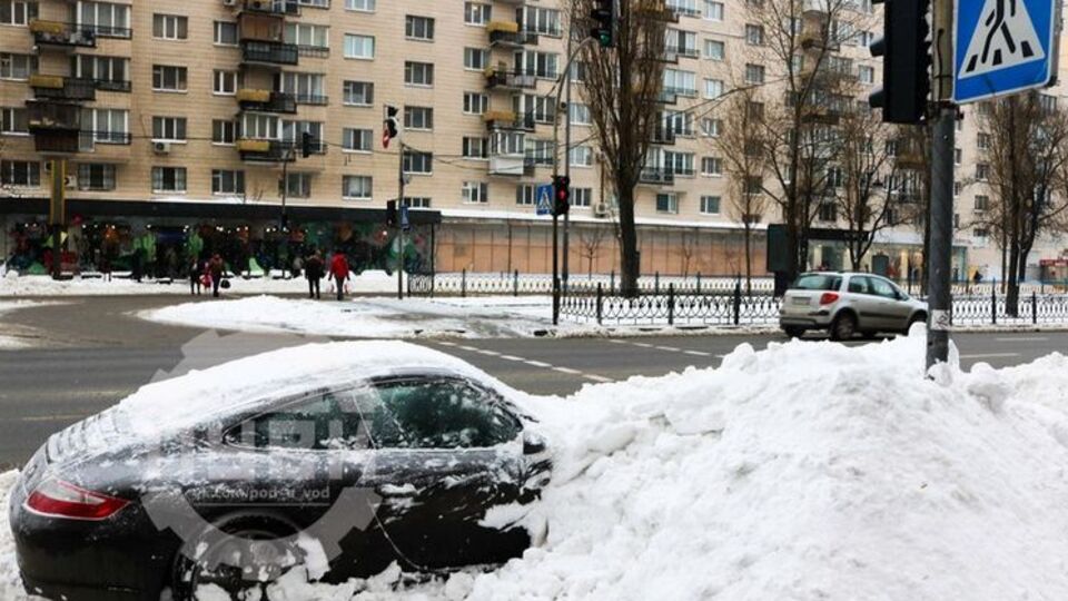 В Киеве коммунальщики засыпали снегом припаркованный Porsche. Фоторепортаж