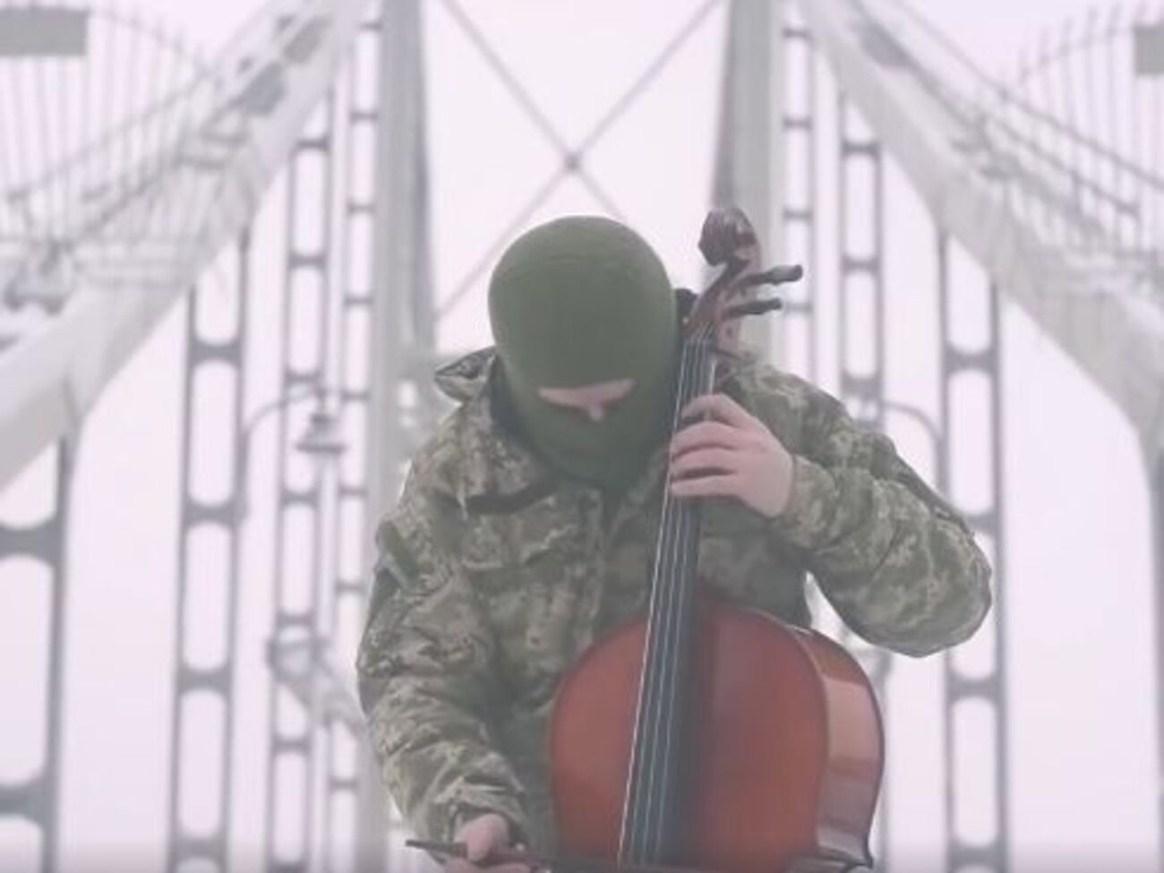 На видео боец АТО, стоя на мосту, исполняет гимн Украины на виолончели