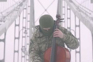 На видео боец АТО, стоя на мосту, исполняет гимн Украины на виолончели