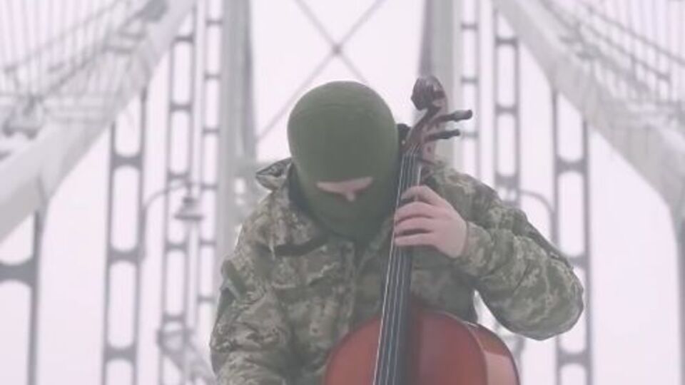 На видео боец АТО, стоя на мосту, исполняет гимн Украины на виолончели