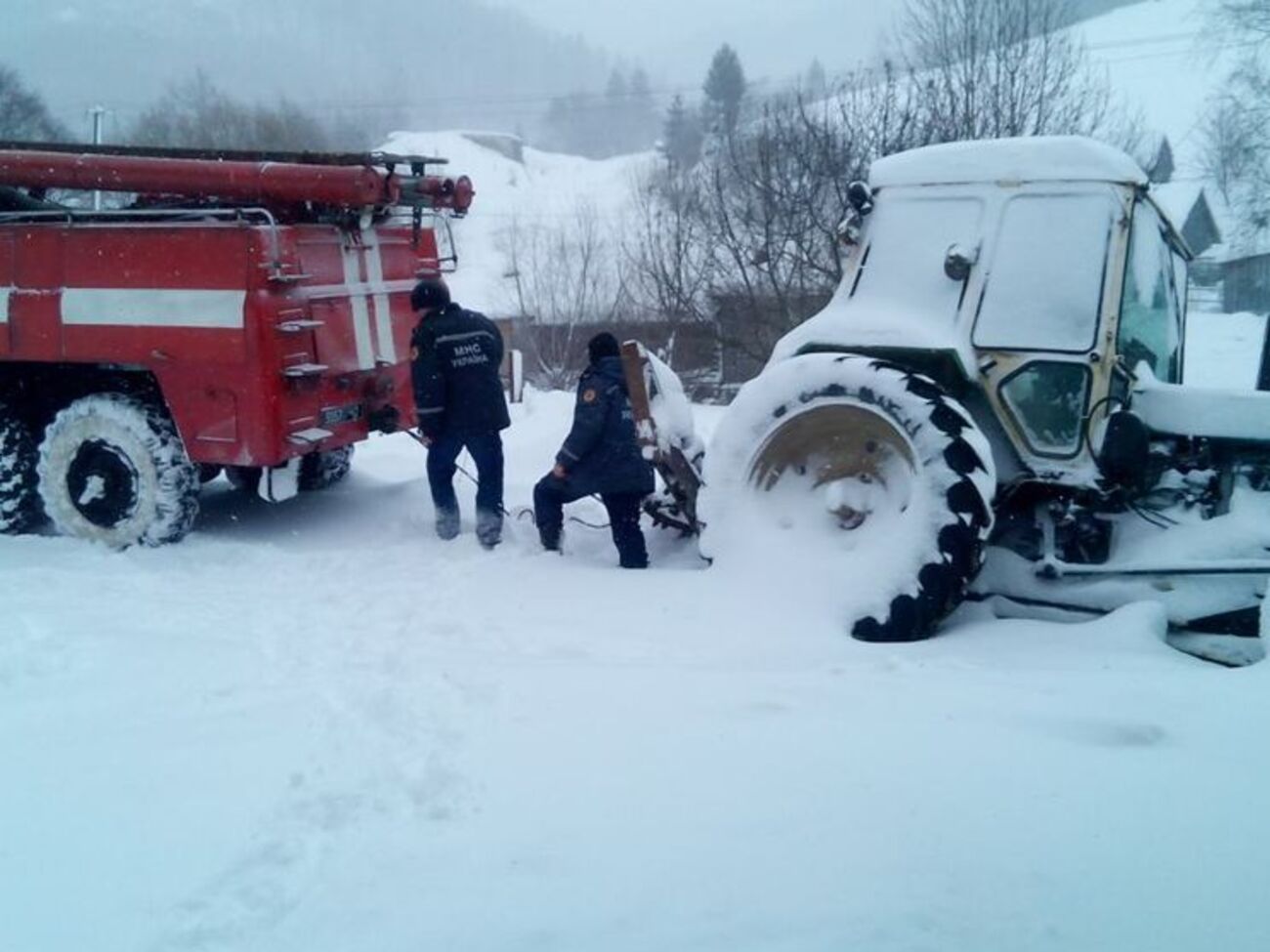 Спасатели помогают отбуксировать грузовой автотранспорт из сугробов