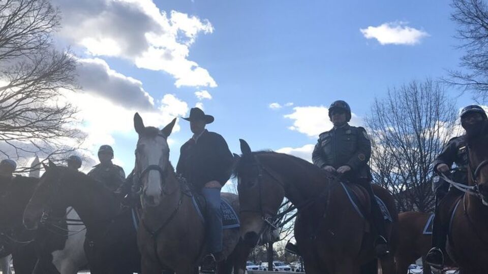 Зинке (в ковбойской шляпе) начал работу на новой должности верхом на лошади