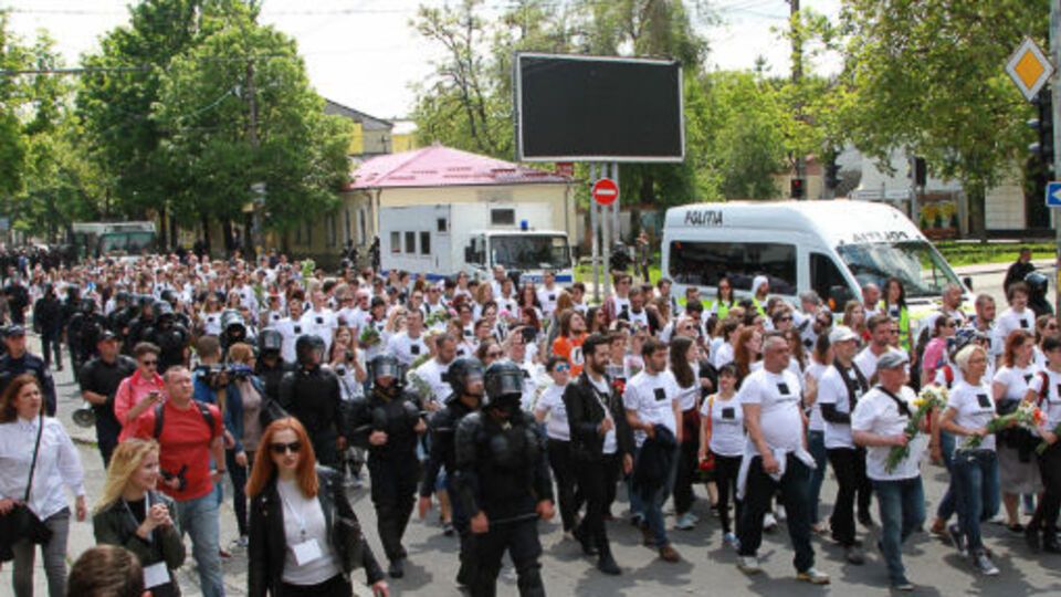 Участники шествия были одеты в белые футболки и несли в руках цветы
