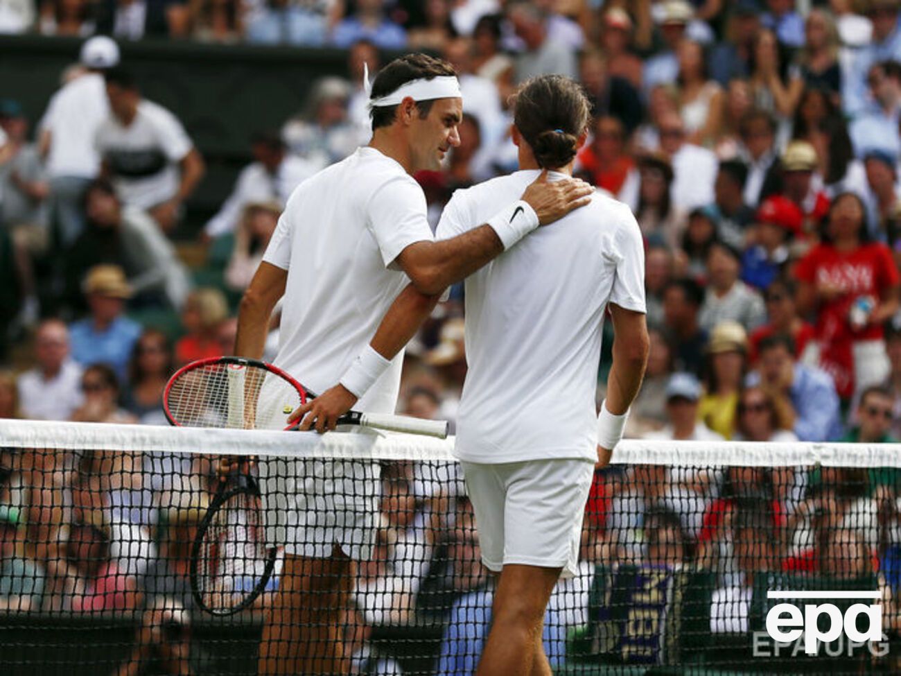 Федерер утешает Долгополова, который не смог доиграть матч из-за травмы