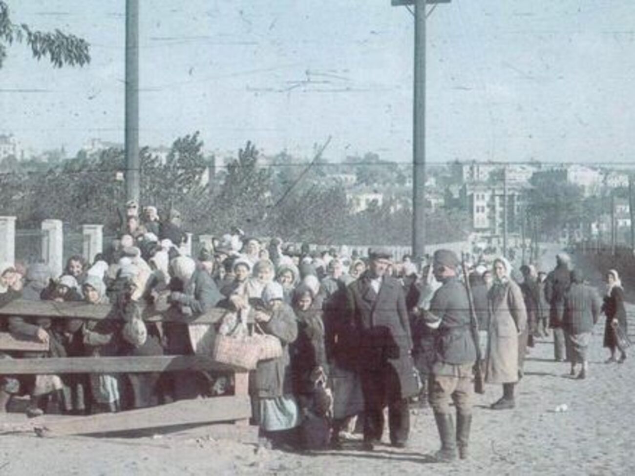 На знімку жінки біля огорожі стадіону "Зеніт" (нині "Старт"), де неподалік у казармах на вулиці Керосинній (Шолуденка) утримували військовополонених