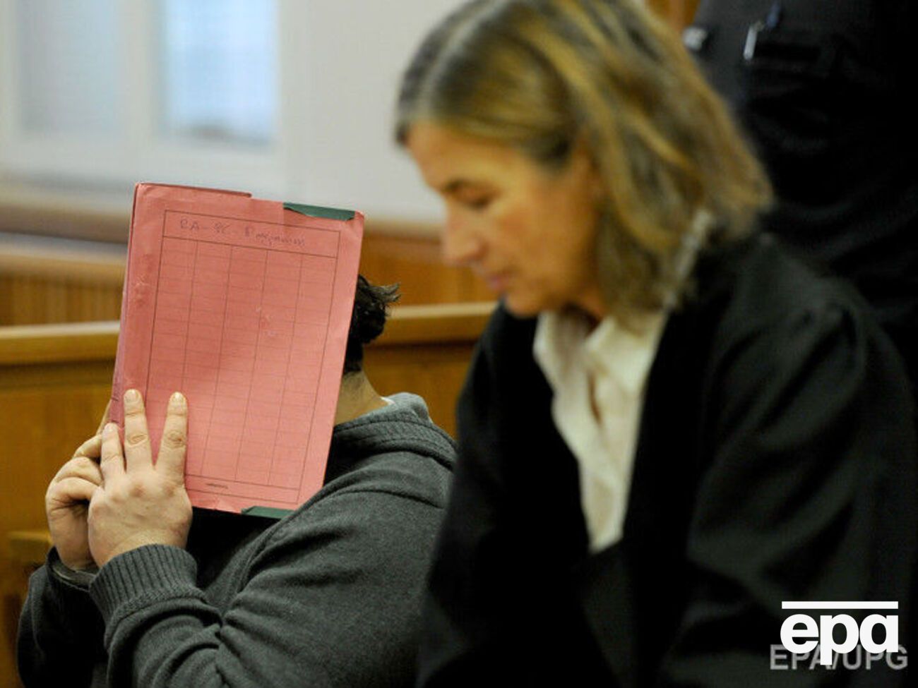 Во время судебного процесса убийца закрывал лицо от фотокамер