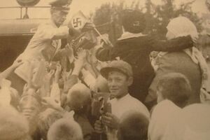 Немецкий чиновник раздает флажки во время празднования второй годовщины освобождения Киева от большевиков. 19 сентября 1943 года