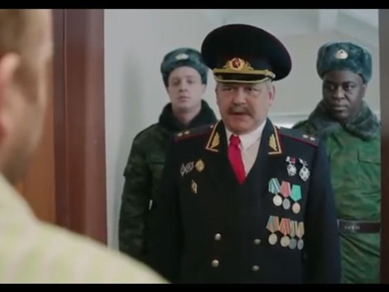 Героя ролика пытаются призвать в армию: повестку ему приносят несколько военных, в том числе темнокожий, что должно олицетворять негативные перемены в России из-за неявки на выборы
