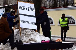 Активисты принесли к зданию консульства гроб с чучелом в маске президента России