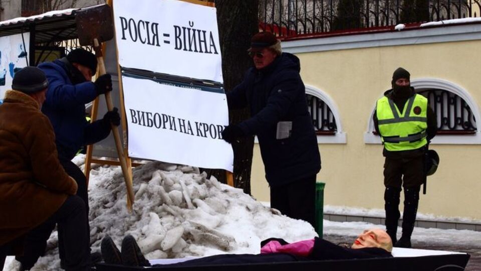 Активисты принесли к зданию консульства гроб с чучелом в маске президента России