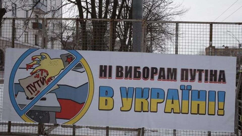 На металлических решетках под посольством РФ развешаны плакаты