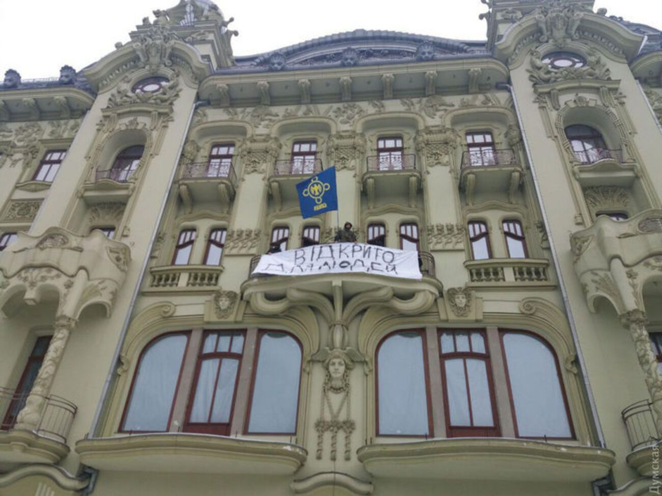 Активисты вывесили на балконе третьего этажа плакат "Відкрито для людей"
