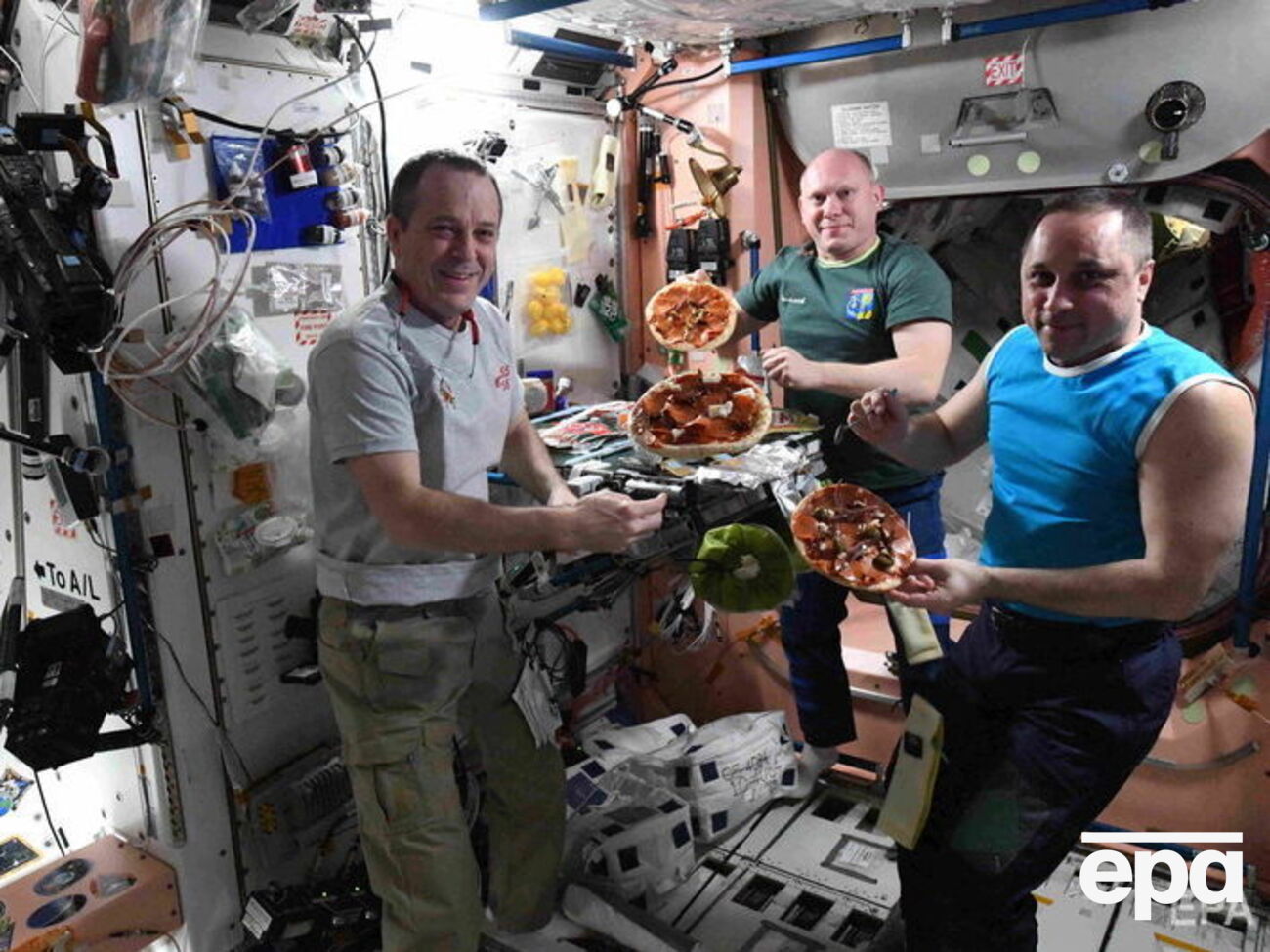 Астронавт НАСА Річард Арнольд та росіяни Олег Артем'єв і Антон Шкаплеров із піцою на борту МКС