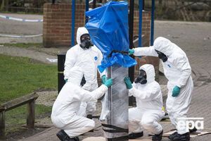 Фахівці одягнені в захисні костюми і протигази