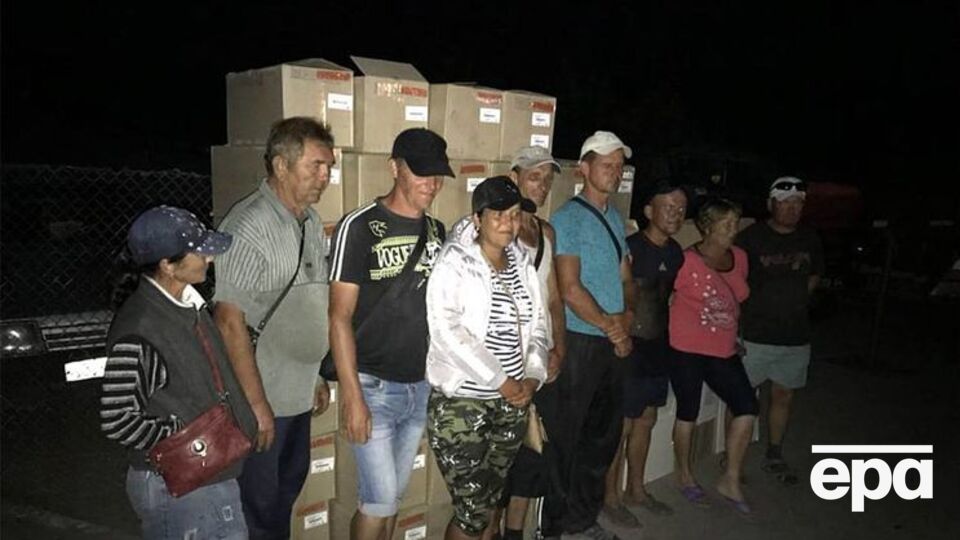 Восемь человек наняли, чтобы вручную перенести груз через контрольный пункт