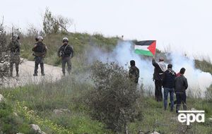 Протестующие бросают взрывные устройства и петарды в сторону забора безопасности