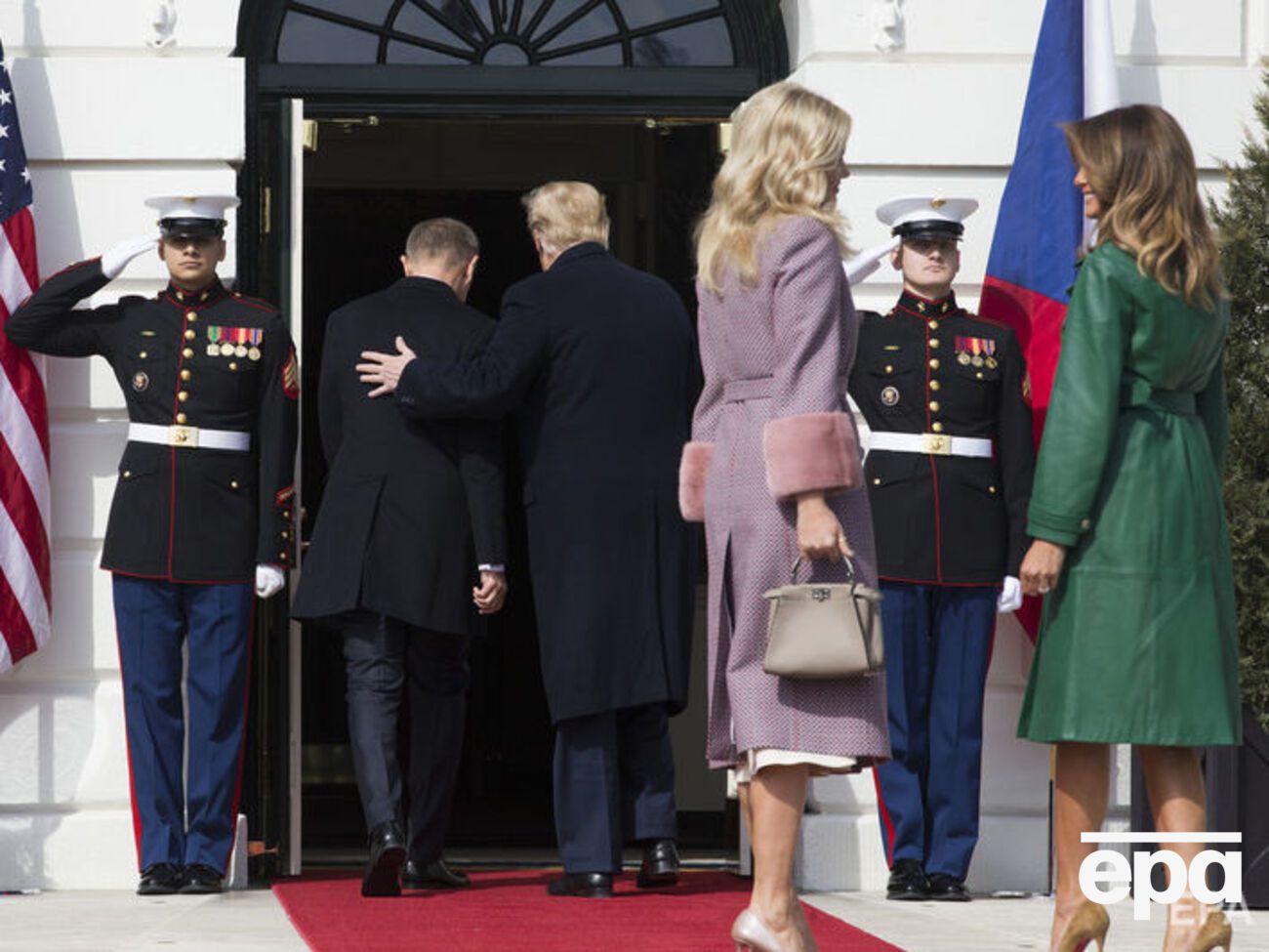 Меланья Трамп (в зеленом плаще) осталась снаружи, когда президент США зашел в Белый дом
