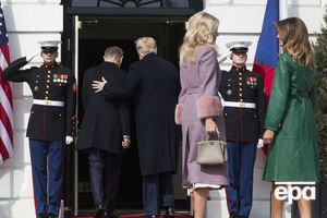 Меланья Трамп (в зеленом плаще) осталась снаружи, когда президент США зашел в Белый дом