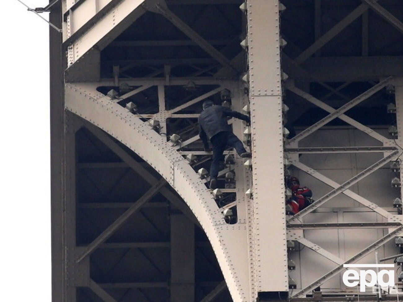 Пожежники спостерігають, як невідомий намагається вилізти на Ейфелеву вежу