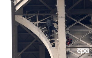 Пожежники спостерігають, як невідомий намагається вилізти на Ейфелеву вежу