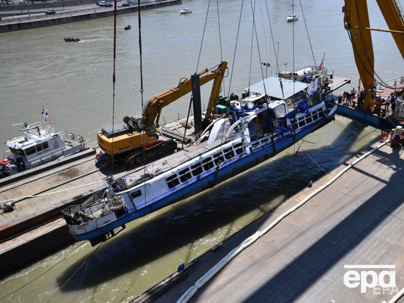 Плавучий кран поднял затонувший катер и поместил его на баржу