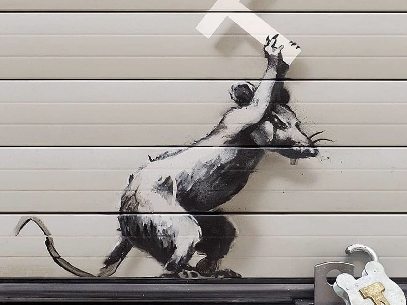 На малюнку щур молотком у вигляді літери "Т" розбиває замок