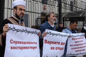 Активисты держали в руках плакаты с требованиями прекратить преследование крымских татар в Крыму