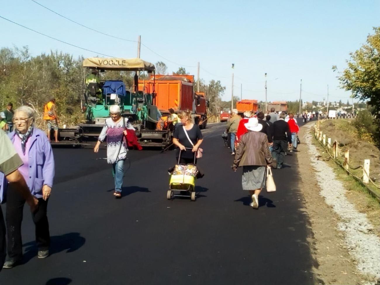 Біля мосту асфальтують дорогу