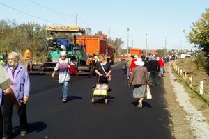 Біля мосту асфальтують дорогу