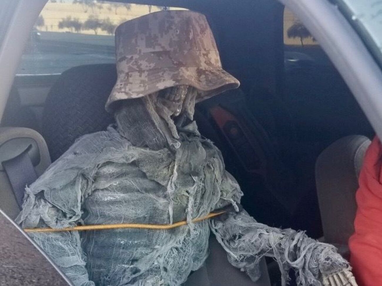 Мужчина одел макет в кепку и обмотал его марлей