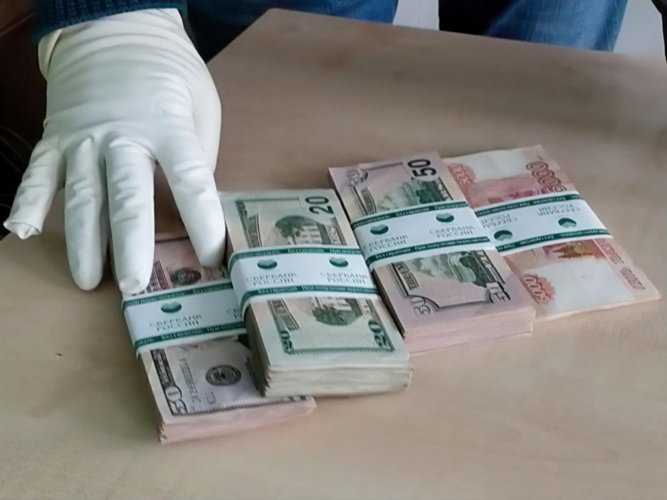 В пакете находились пачки с долларами и российскими рублями в обертке "Сбербанка России"