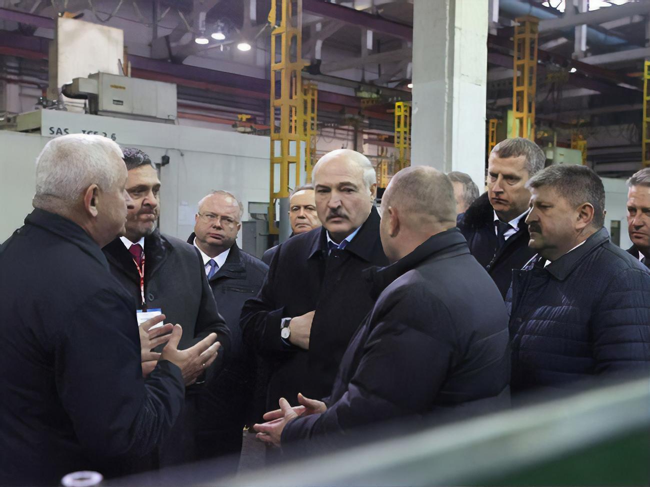 Лукашенко (в центре) рассказывал о работе разведчиков во время посещения завода