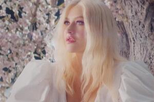 Агилера появляется в кадре в белом платье среди цветущих деревьев
