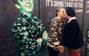 Эдвардс и Пиплс позируют на фоне изображения журналистки Лиры Макки, которая выступала за легализацию однополых браков